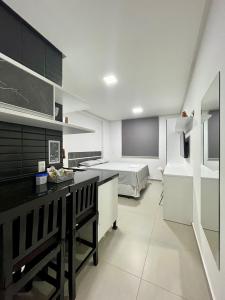 a room with a kitchen and a bed in the background at Westfit Barreto 03 in Mossoró