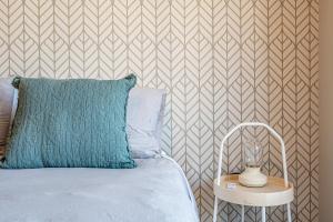 a bed with a blue pillow and a side table at M&C Departamento Irarrazaval 614 in Santiago