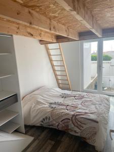 a bedroom with a bed and a ladder and a window at Sion sur locean - trois chambres in Saint-Hilaire-de-Riez