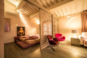 een slaapkamer met een bed en twee rode stoelen bij Steccaia Holiday Home in Villa del Monte