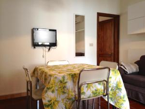 Pokój ze stołem z krzesłami i telewizorem na ścianie w obiekcie Spina Green 42 w mieście Lido di Spina