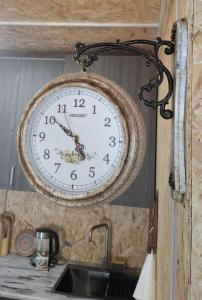 eine Uhr, die an einer Wand über einer Küchenspüle hängt in der Unterkunft Stepanavan Forest House in Stepanawan