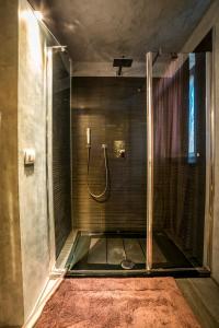 een douche met een glazen deur in de badkamer bij Steccaia Holiday Home in Villa del Monte
