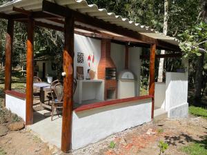 a wooden pavilion with a fireplace in a yard at Casa da Dorinha in Teresópolis +5 photos