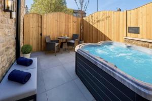 a hot tub on a patio with a table and chairs at Blossom Tree Cottage in Barnoldswick