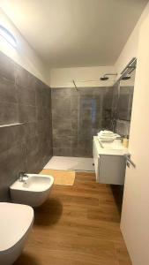 a bathroom with two sinks and a toilet and a shower at BELLAViTA LAKE GARDA Apartments in Arco