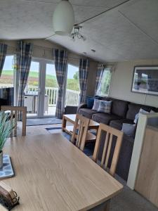 a living room with a table and a couch at Carnoustie 24 - Turnberry Holiday Park - short walk to beach in Girvan