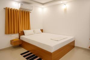 a bedroom with a white bed with a window at PY OLLIV Chennai THIRUVALLUR in Kaklūr