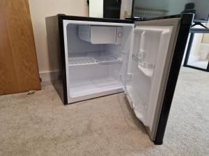 an empty refrigerator with its door open in a room at West Beck House Darlington - Penthouse Double En-Suite in Darlington