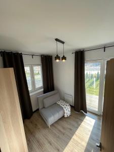 a living room with a couch and a window at Apartamenty Łuska w Dębinie in Debina