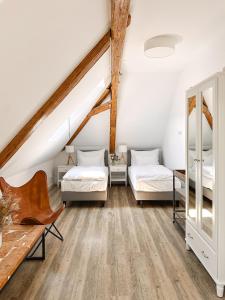 a attic bedroom with two beds and a table at Na Kmíně in Obříství +98 photos