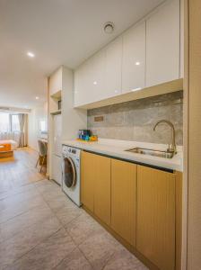 a kitchen with a sink and a washing machine at Hong Ge Apartment Hotel in Shanghai +11 photos
