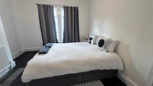 Un dormitorio con una cama grande con sábanas y almohadas blancas. en Perfect room 4, en Bristol 5 fotos más