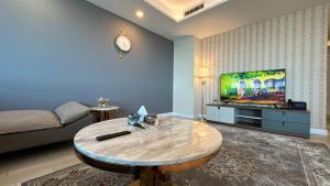 een woonkamer met een salontafel en een tv bij Luxury 3-Bedroom Apartment at Centaurus City View in Islamabad