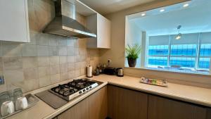 een keuken met een fornuis bovenste oven naast een raam bij Luxury 3-Bedroom Apartment at Centaurus City View in Islamabad