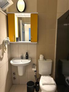 a bathroom with a toilet and a sink and a mirror at Ayshira Aparts in Kemer