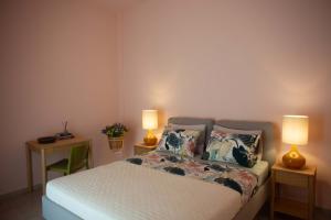 a bedroom with a bed with two lamps on two tables at Ann's apartment II in Lixouri