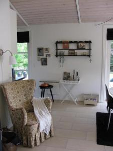 a living room with a chair and a table at Nice Home In Nykøbing Sjælland W in Nykøbing Sjælland +10 photos
