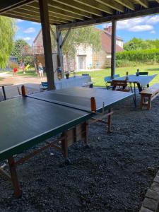 two ping pong tables sitting under a pavilion at Les Mariniers Chambres d'Hôtes à la campagne avec aire de jeux - Spa nordique en option in Mareuil-sur-Cher