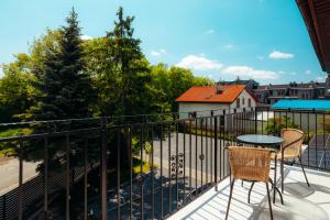 a balcony with a table and chairs and a fence at Komfortowy apartament w spokojnej dzielnicy in Wrocław