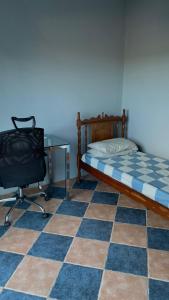 a bedroom with a bed and a desk and a chair at Casa 319 in São José dos Campos +3 photos