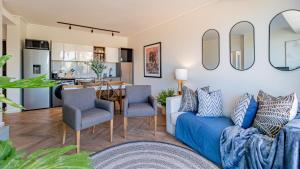 a living room with a blue couch and chairs at Table Mountain View Apartment in Cape Town