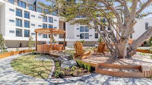 a park with chairs and a tree with a building at Table Mountain View Apartment in Cape Town
