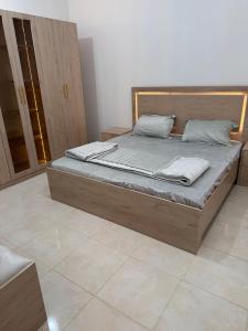 a bed with a wooden frame in a room at جدة الفلاح in Quai