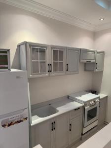 a kitchen with white cabinets and a sink at جدة الفلاح in Quai