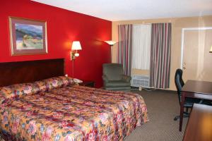 a hotel room with a bed and a desk and a chair at Valustay Inn Shakopee in Shakopee