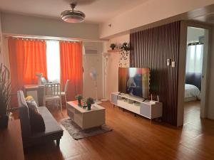 大雅台Family Haven Tagaytay - 6 Pax - Taal View - Full Kitchen - FAST Wi-Fi SERIN WEST CONDO的配有平板电视和沙发的客厅
