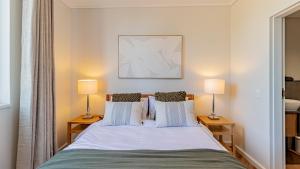 a bedroom with a bed with two lamps on tables at Table Mountain View Apartment in Cape Town