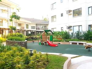 大雅台Family Haven Tagaytay - 6 Pax - Taal View - Full Kitchen - FAST Wi-Fi SERIN WEST CONDO的大楼前带滑梯的游乐场