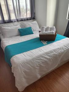 大雅台Family Haven Tagaytay - 6 Pax - Taal View - Full Kitchen - FAST Wi-Fi SERIN WEST CONDO的一张大白色的床,上面有篮子