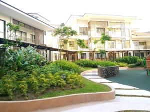 大雅台Family Haven Tagaytay - 6 Pax - Taal View - Full Kitchen - FAST Wi-Fi SERIN WEST CONDO的一座带花园的公寓大楼的庭院