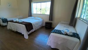 a room with two beds and a window at Selah Estação Ecológica in Cocalzinho de Goias