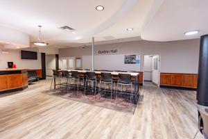 ein großer Raum mit einer Bar und Barhockern darin in der Unterkunft Gordon Hall Residence in Guelph
