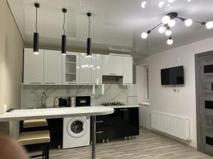 eine Küche mit weißen Schränken und einer Waschmaschine in der Unterkunft 1-Confortable and ideal Apartament-Квартира посуточно Edinet in Edineţ