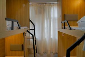 a room with two bunk beds and a window at Waveflo Hostel 浪花青旅 in Hong Kong