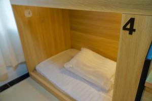 a small bed in a wooden cabinet with a pillow at Waveflo Hostel 浪花青旅 in Hong Kong