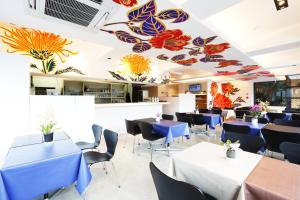 a restaurant with blue tables and chairs and butterflies painted on the ceiling at Kyoto Travellers Inn in Kyoto