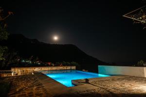 a swimming pool at night with the moon in the sky at Villa Verra in Pržno +31 photos