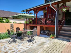 a patio with a table and chairs and an umbrella at Pensiunea Mallorca Restaurant - Bar in Vişeu de Sus +23 photos