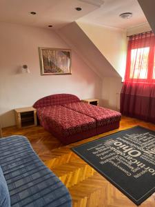 a bedroom with a red bed and a rug at Kristóf Vendégház in Hajdúszoboszló +24 photos