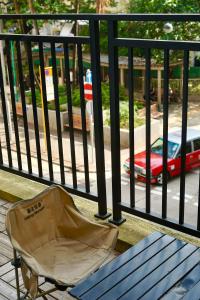 a chair sitting on a balcony with a view of a street at Waveflo Hostel 浪花青旅 in Hong Kong