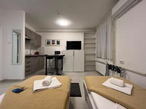 a kitchen with two tables and a white refrigerator at Rijeka Budget Rooms in Rijeka