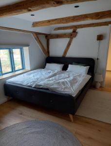 a large bed in a room with wooden ceilings at ALTE SCHEUNE Ferienwohnungen - Wohnung 4 in Suderburg