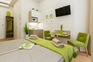 Una habitación con una cama con sillas verdes y una cocina en Budapest Holiday Colours, en Budapest