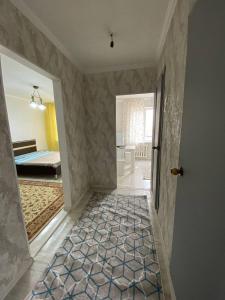 a hallway with a room with a bed and a door at Уютные апартаменты в 11 микрорайоне in Aktobe