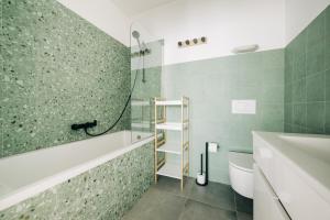 ein Badezimmer mit Badewanne, Toilette und Waschbecken in der Unterkunft Octopus House Caparica in Costa da Caparica + 85 Fotos